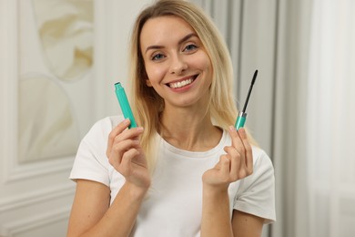 Beautiful happy woman with mascara at home