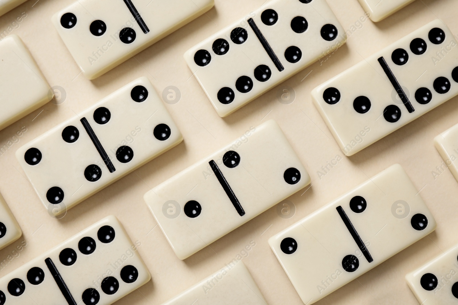 Photo of Classic domino tiles on beige background, flat lay