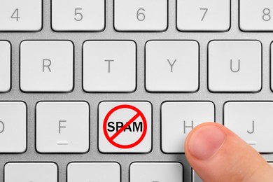 Image of Prohibition sign with word Spam on button, top view. Man using computer keyboard, closeup