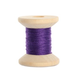 Photo of Wooden spool of purple sewing thread isolated on white