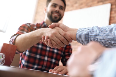 Photo of Business partners shaking hands after meeting, closeup