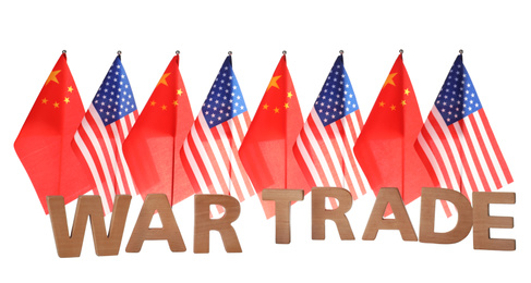 Photo of USA and China flags behind phrase WAR TRADE of wooden letters on white background