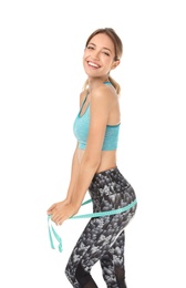 Happy slim woman in sportswear with measuring tape on white background. Positive weight loss diet results