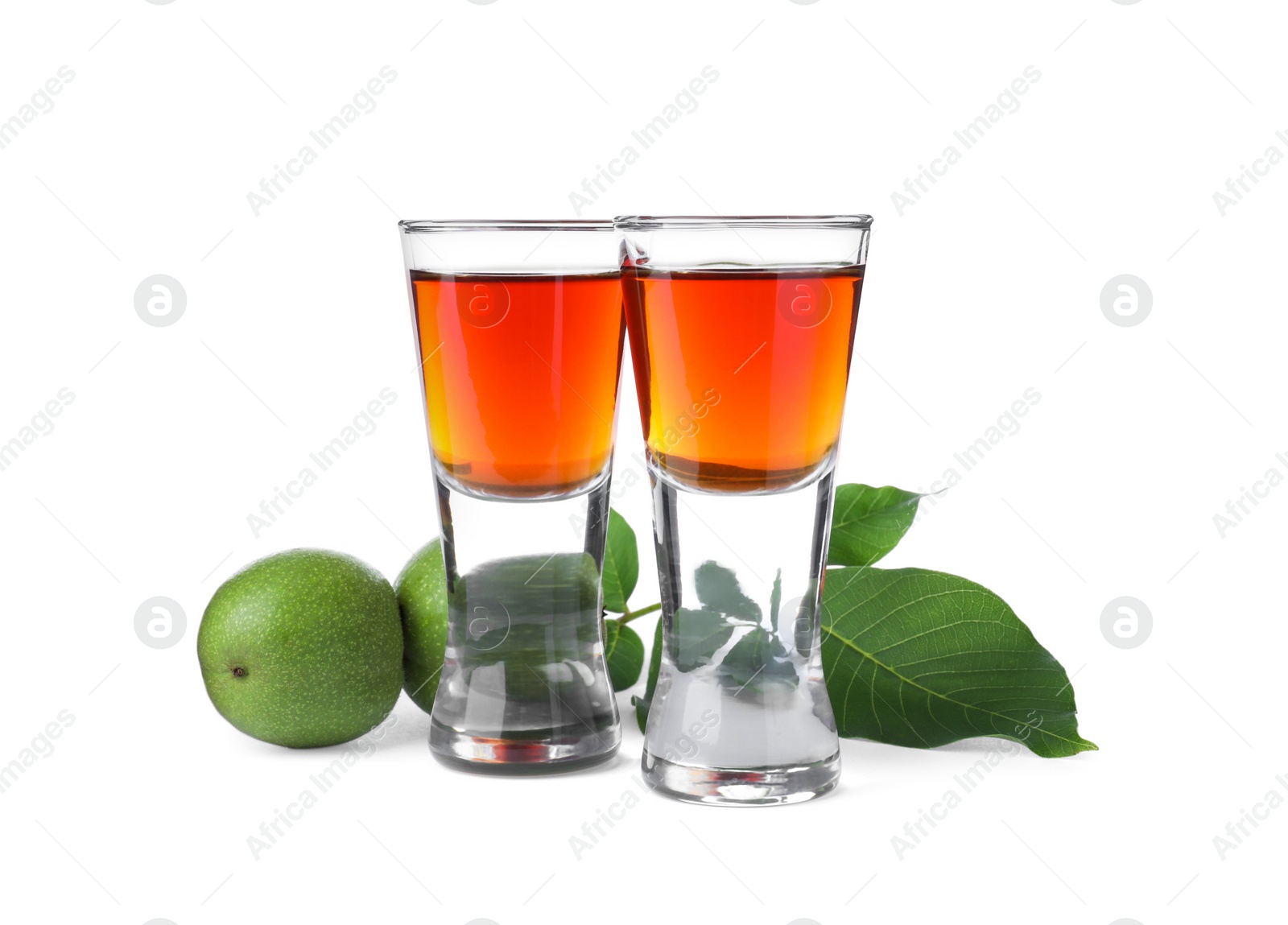 Photo of Delicious liqueur and green walnuts on white background