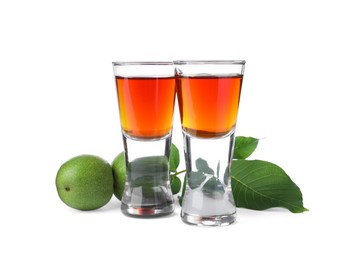 Photo of Delicious liqueur and green walnuts on white background