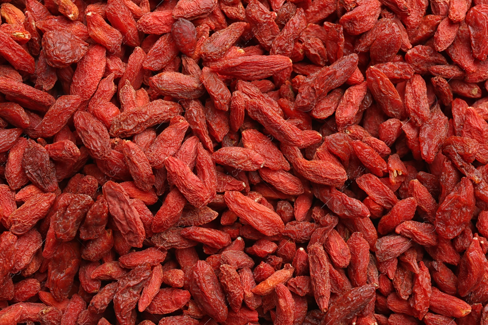 Photo of Many dried goji berries as background, closeup. Healthy superfood