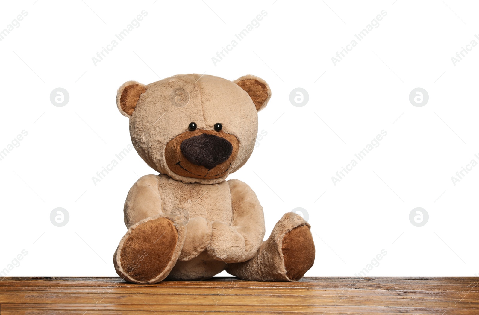 Photo of Cute teddy bear on wooden table against white background