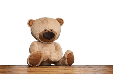 Photo of Cute teddy bear on wooden table against white background