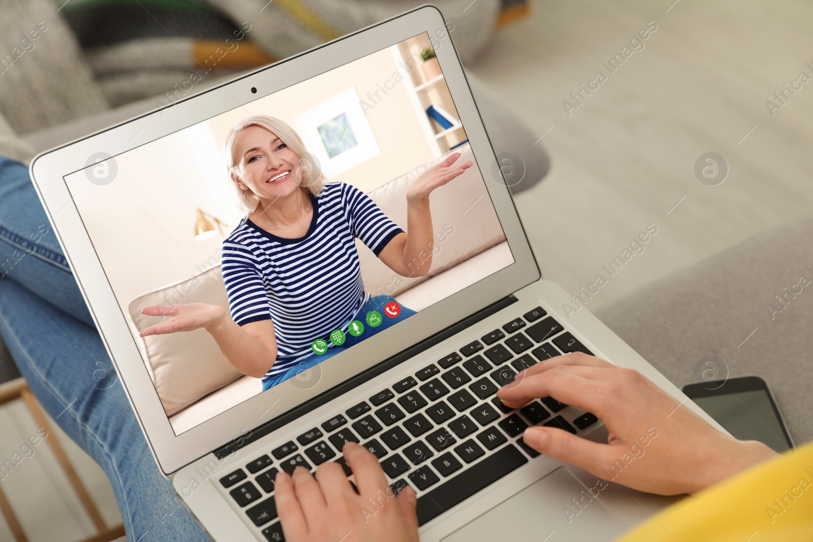 Image of Young woman having video chat with her grandmother at home, focus on screen