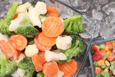 Photo of Mix of different frozen vegetables with ice on grey table, flat lay