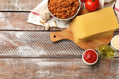 Photo of Flat lay composition with products for cooking lasagna on wooden rustic table. Space for text