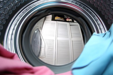 Clothes in washing machine indoors, view from inside. Laundry day