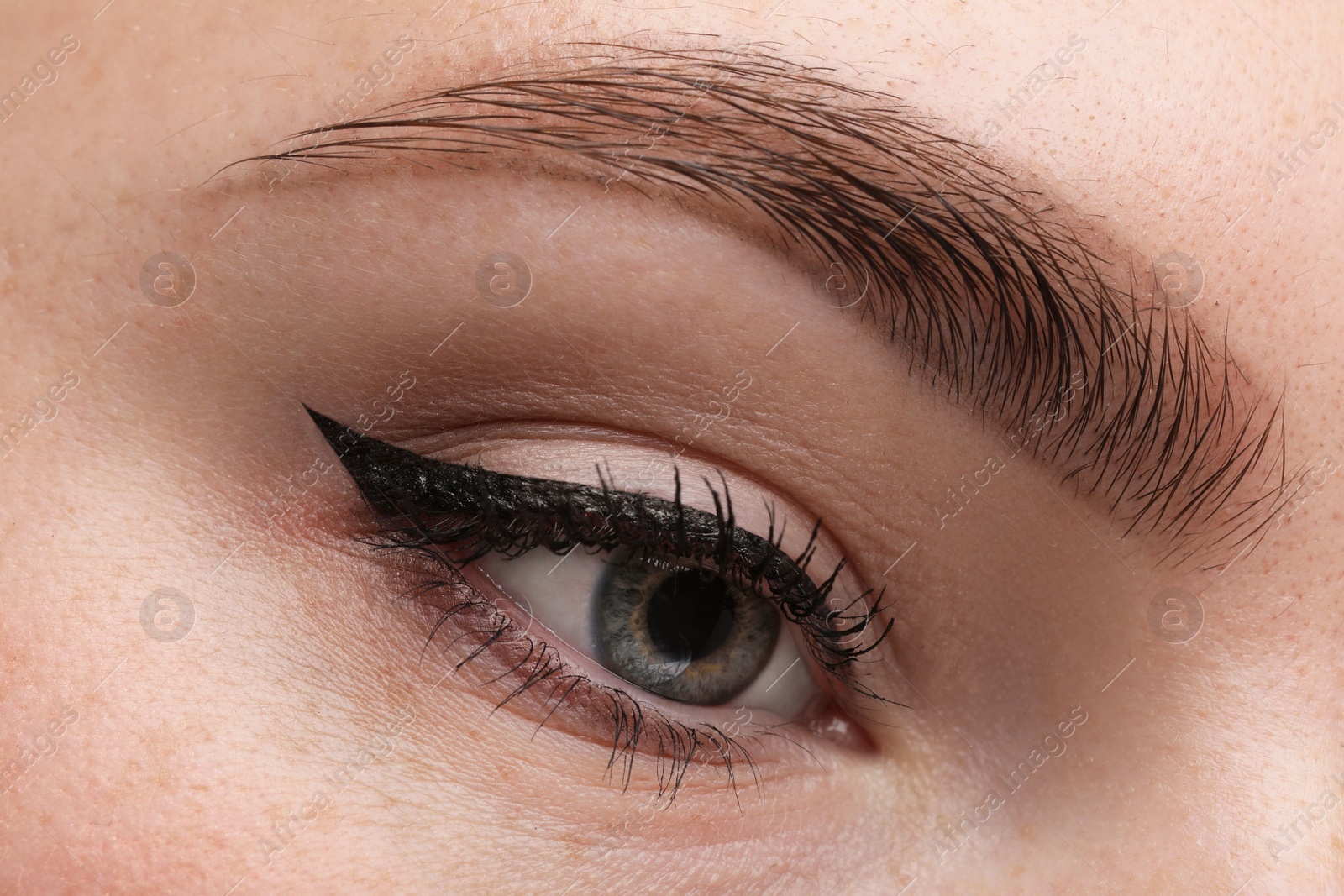 Photo of Makeup product. Woman with black eyeliner and beautiful eyebrow, closeup