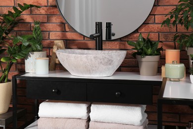 Photo of Stylish sink and beautiful green houseplants in bathroom. Interior design