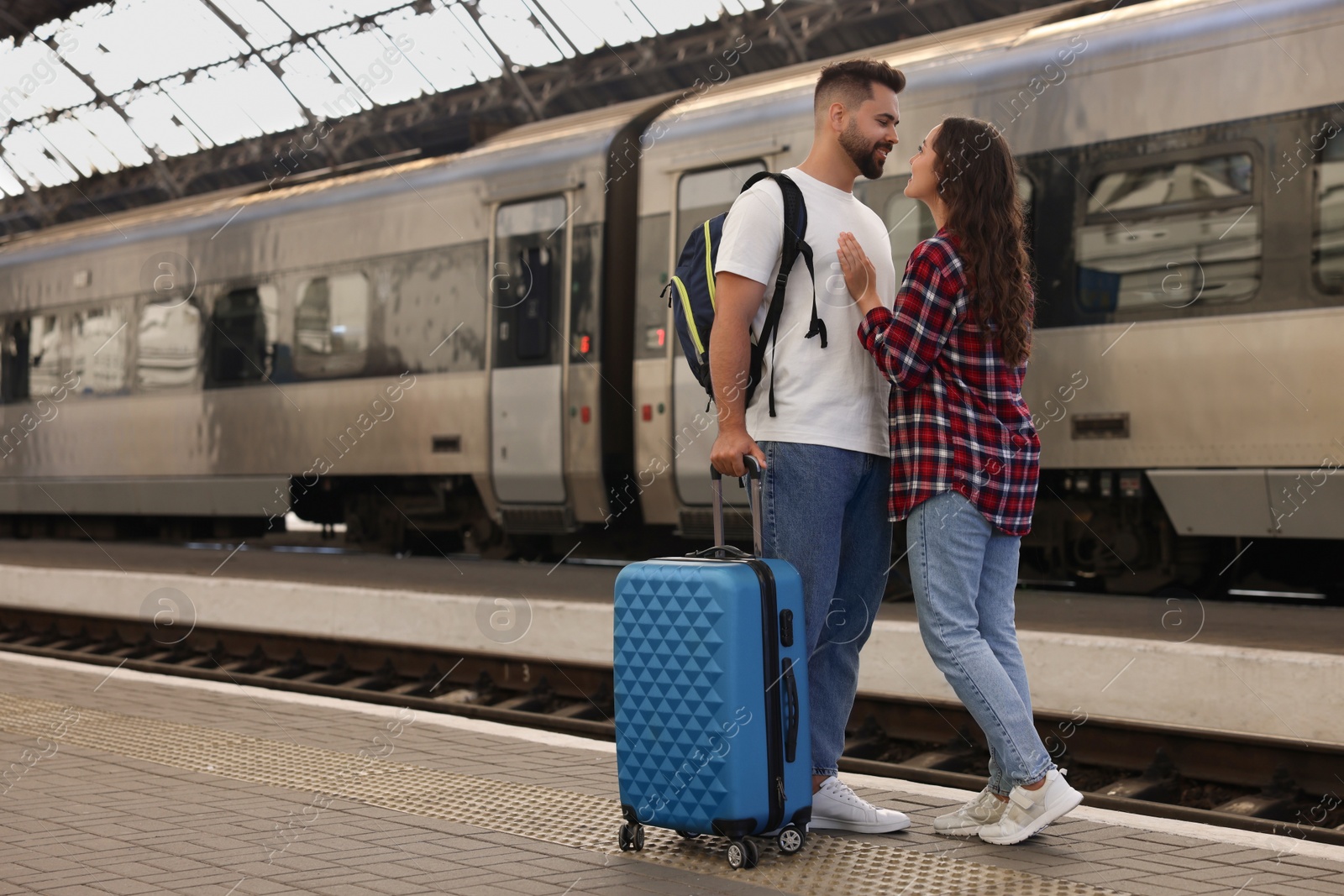 Photo of Long-distance relationship. Beautiful couple on platform of railway station, space for text