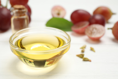 Photo of Natural grape seed oil on white wooden table. Organic cosmetic