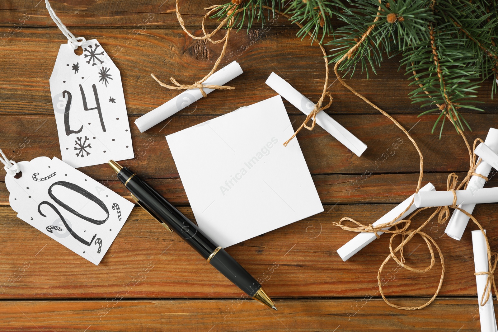 Photo of Flat lay composition with paper notes and fir tree on wooden table. Creating advent calendar