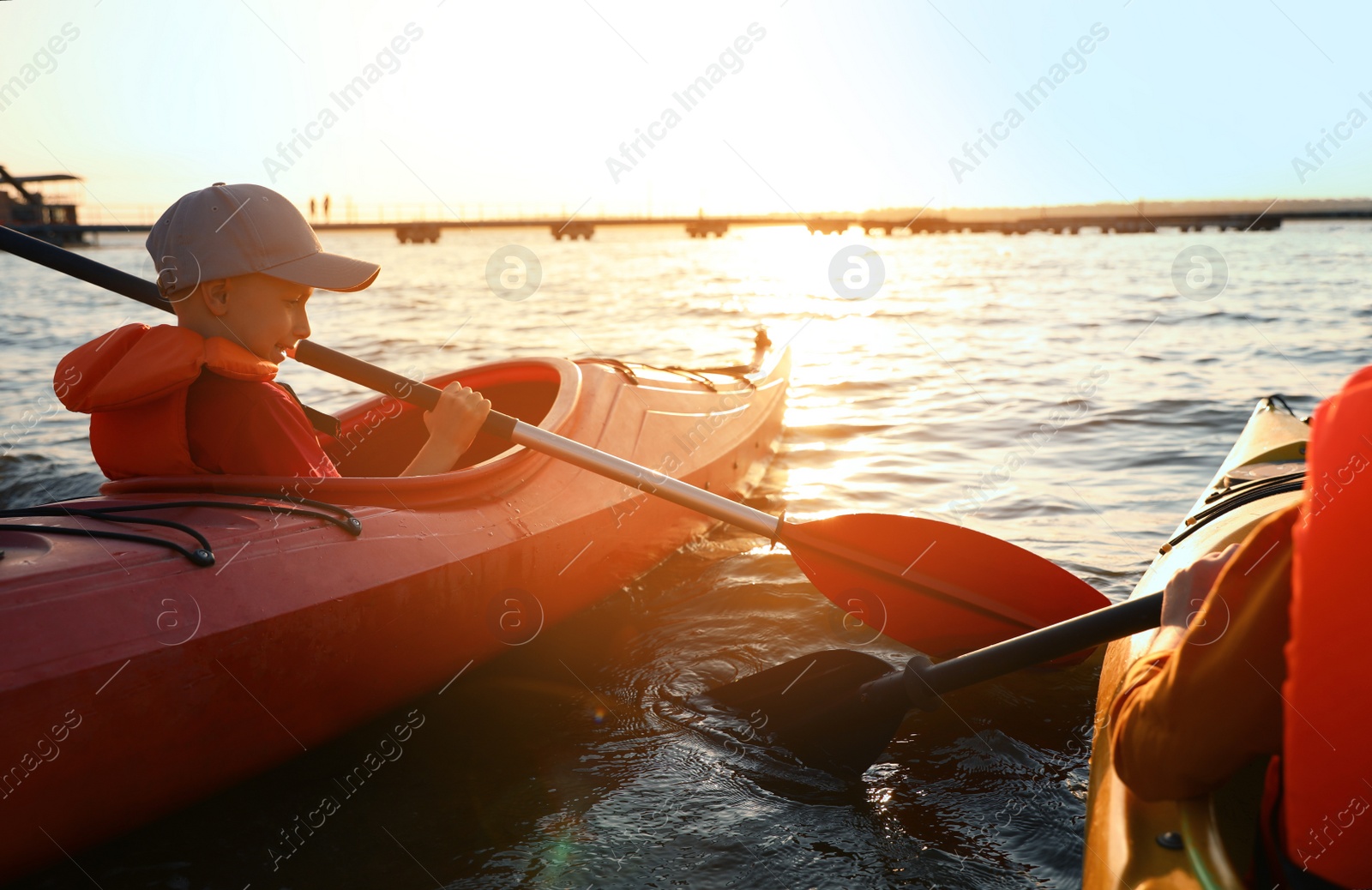 Photo of Little children kayaking on river. Summer camp activity