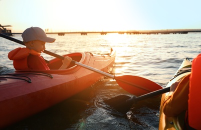 Photo of Little children kayaking on river. Summer camp activity