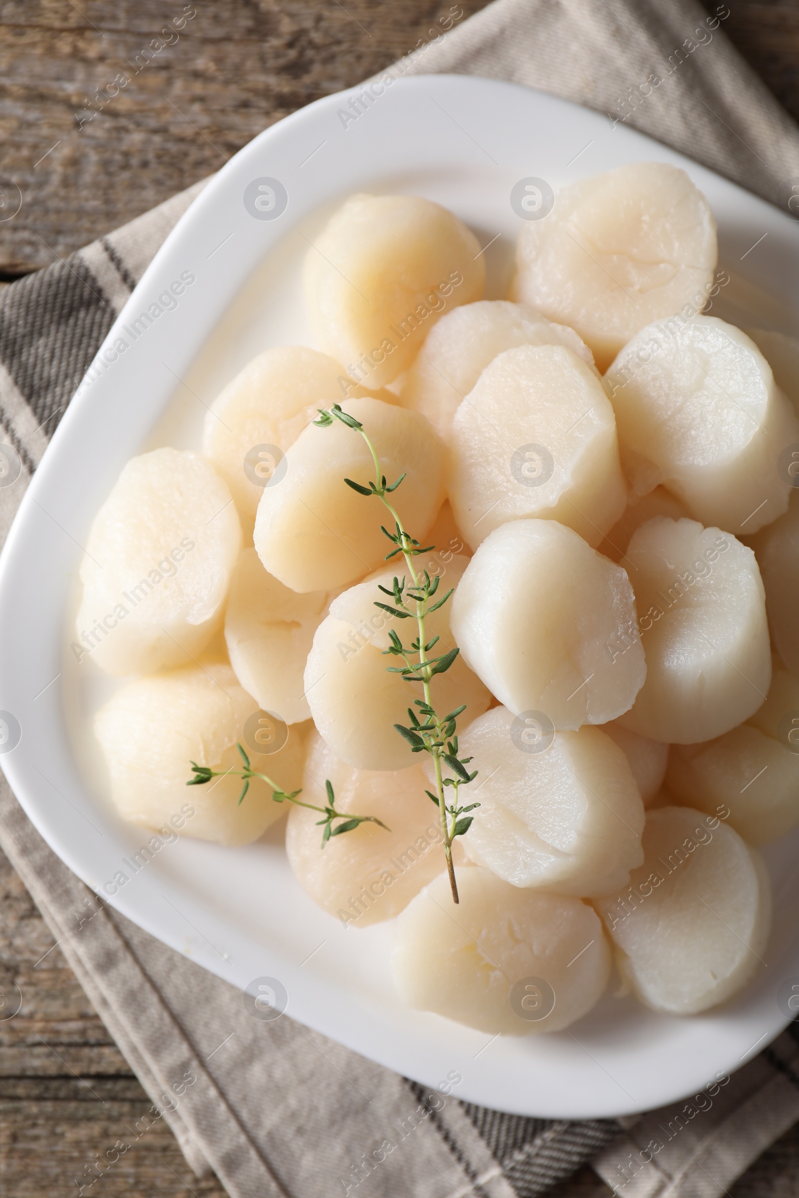 Photo of Fresh raw scallops and thyme on wooden table, top view