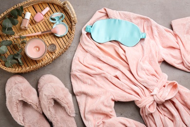 Photo of Flat lay composition with fluffy slippers and robe on grey background. Comfortable home outfit