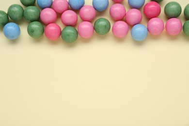 Photo of Many bright chewy gumballs on beige background, flat lay. Space for text