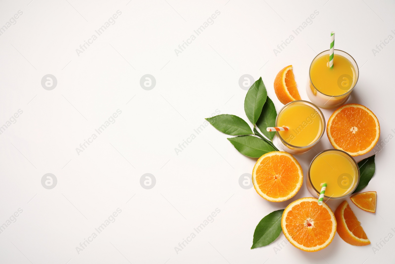 Photo of Glasses of orange juice and fresh fruits on white background, top view