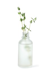Photo of Bottle of essential oil and thyme isolated on white