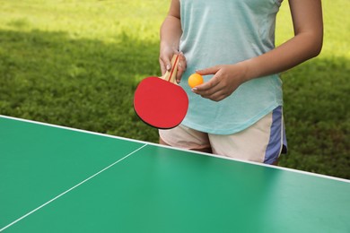 Young woman playing ping pong in park, closeup