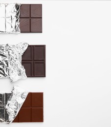 Tasty chocolate bars on white background, top view