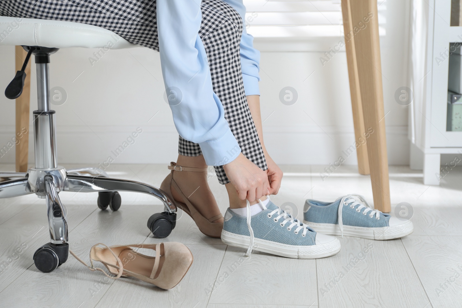 Photo of Woman changing shoes at workplace in office, closeup