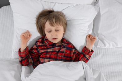 Photo of Little boy snoring while sleeping in bed, top view