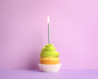 Photo of Birthday cupcake with candle on violet background