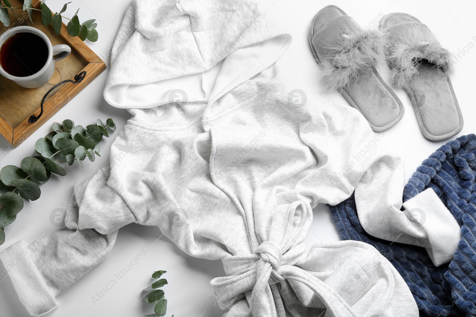 Photo of Composition with fluffy slippers and robe on white background, flat lay. Comfortable home outfit