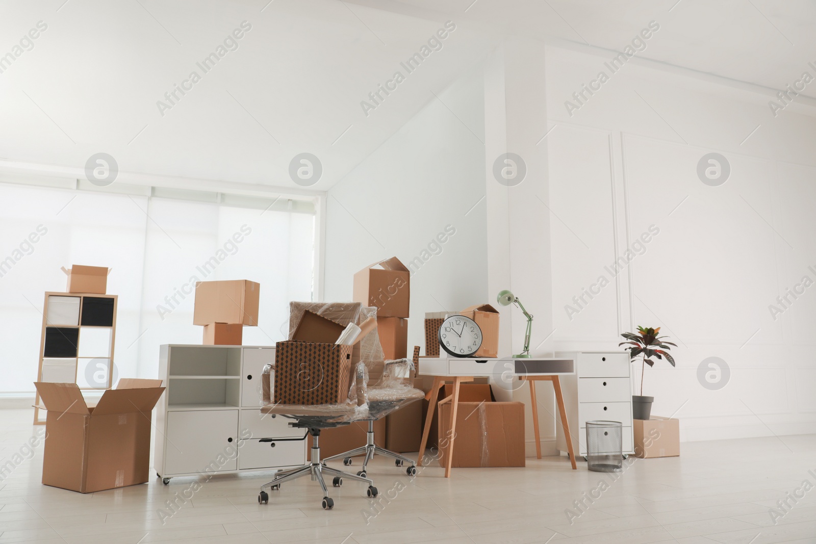 Photo of Cardboard boxes and packed stuff in office. Moving day