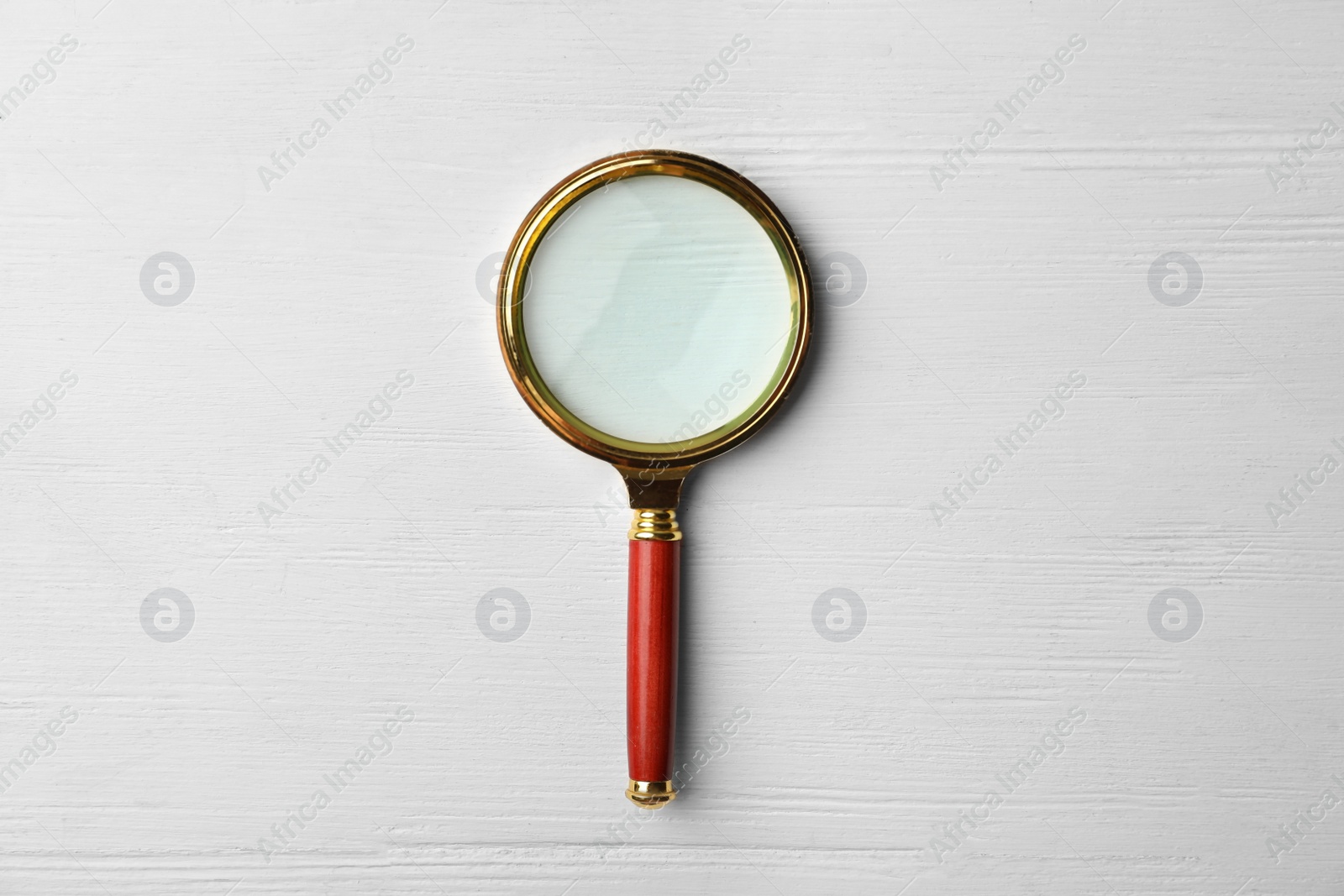 Photo of Magnifier glass on white wooden background, top view. Find keywords concept