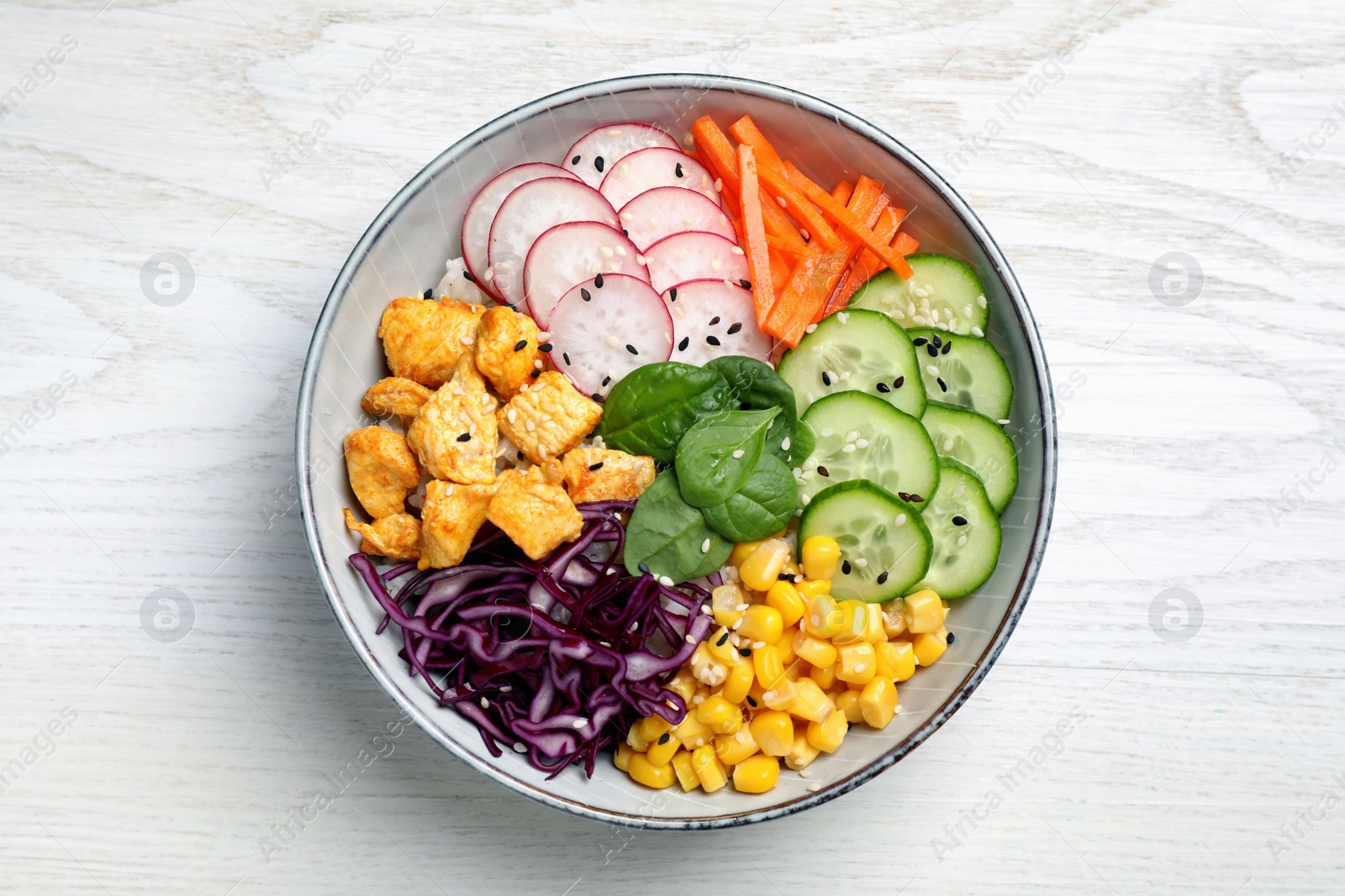 Photo of Delicious salad with chicken, vegetables and spinach on white wooden table, top view