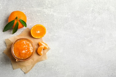 Photo of Flat lay composition with delicious tangerine jam on light grey table. Space for text