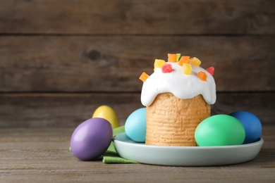 Traditional Easter cake and colorful eggs on wooden table. Space for text