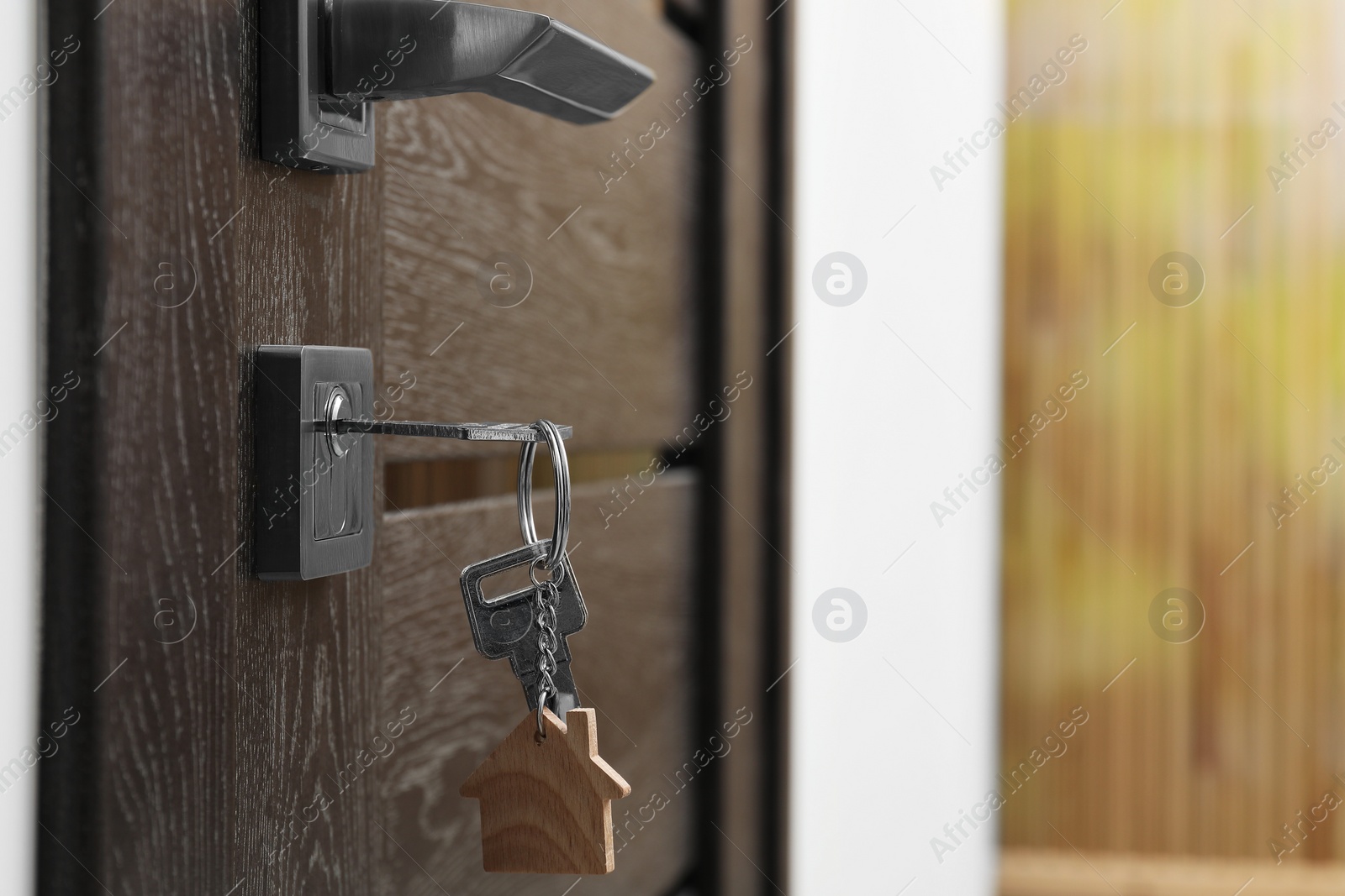 Photo of Door with key and keychain in shape of house. Space for text