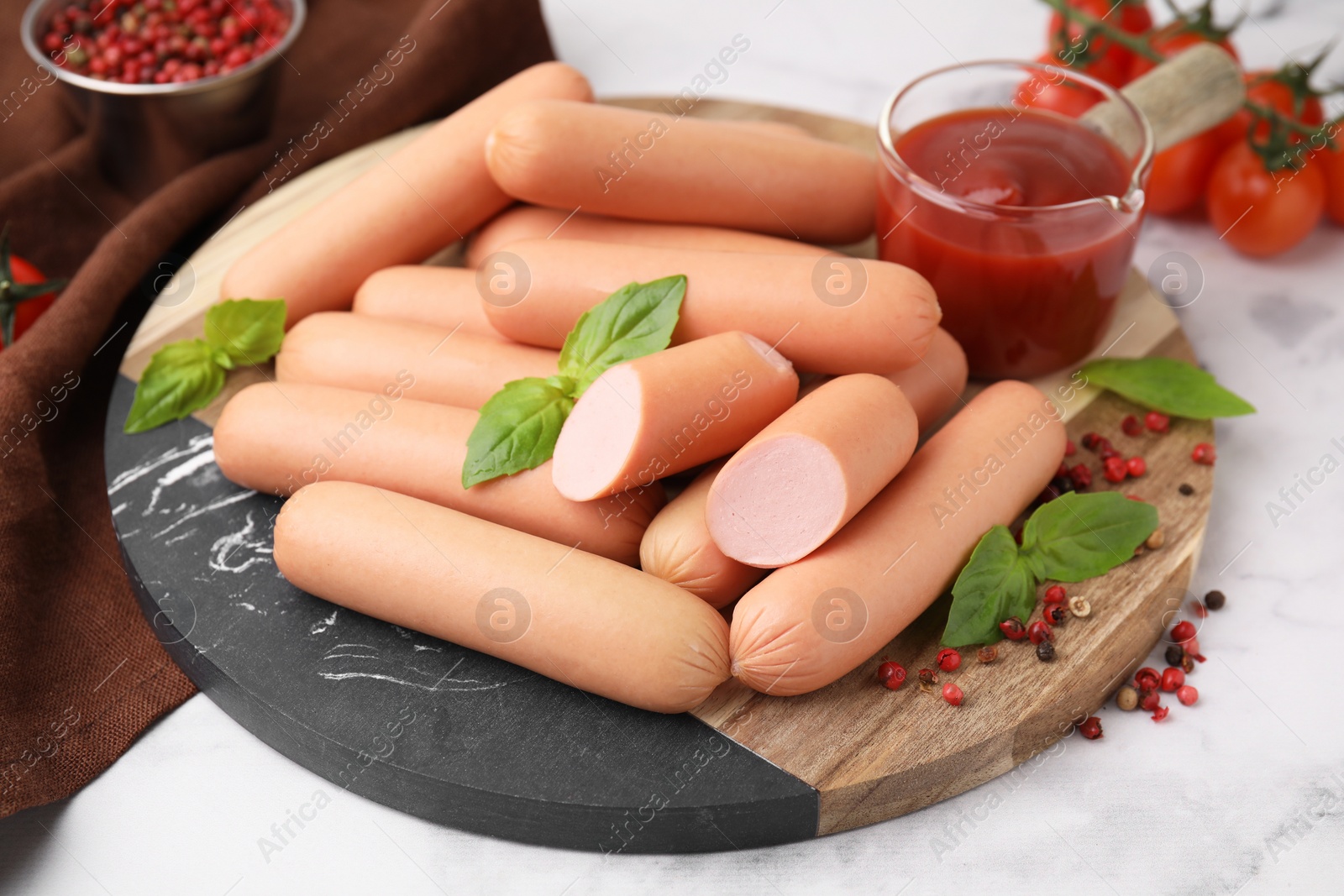 Photo of Delicious boiled sausages, spices and sauce on white marble table, closeup