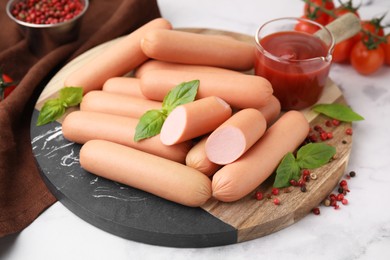 Photo of Delicious boiled sausages, spices and sauce on white marble table, closeup