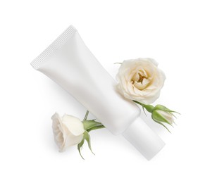Photo of Tube of hand cream and roses on white background, top view