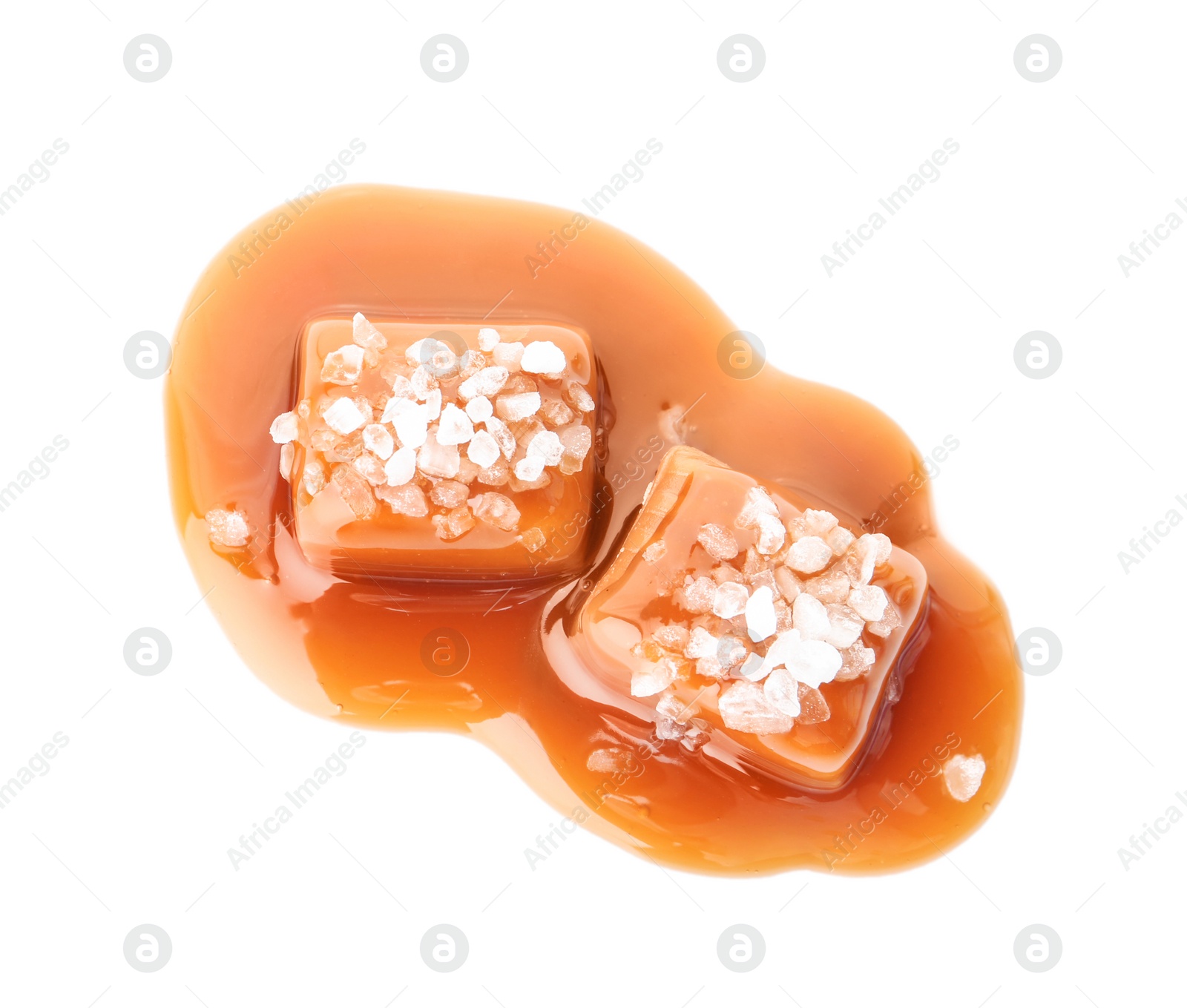 Photo of Delicious candies with caramel sauce and salt on white background