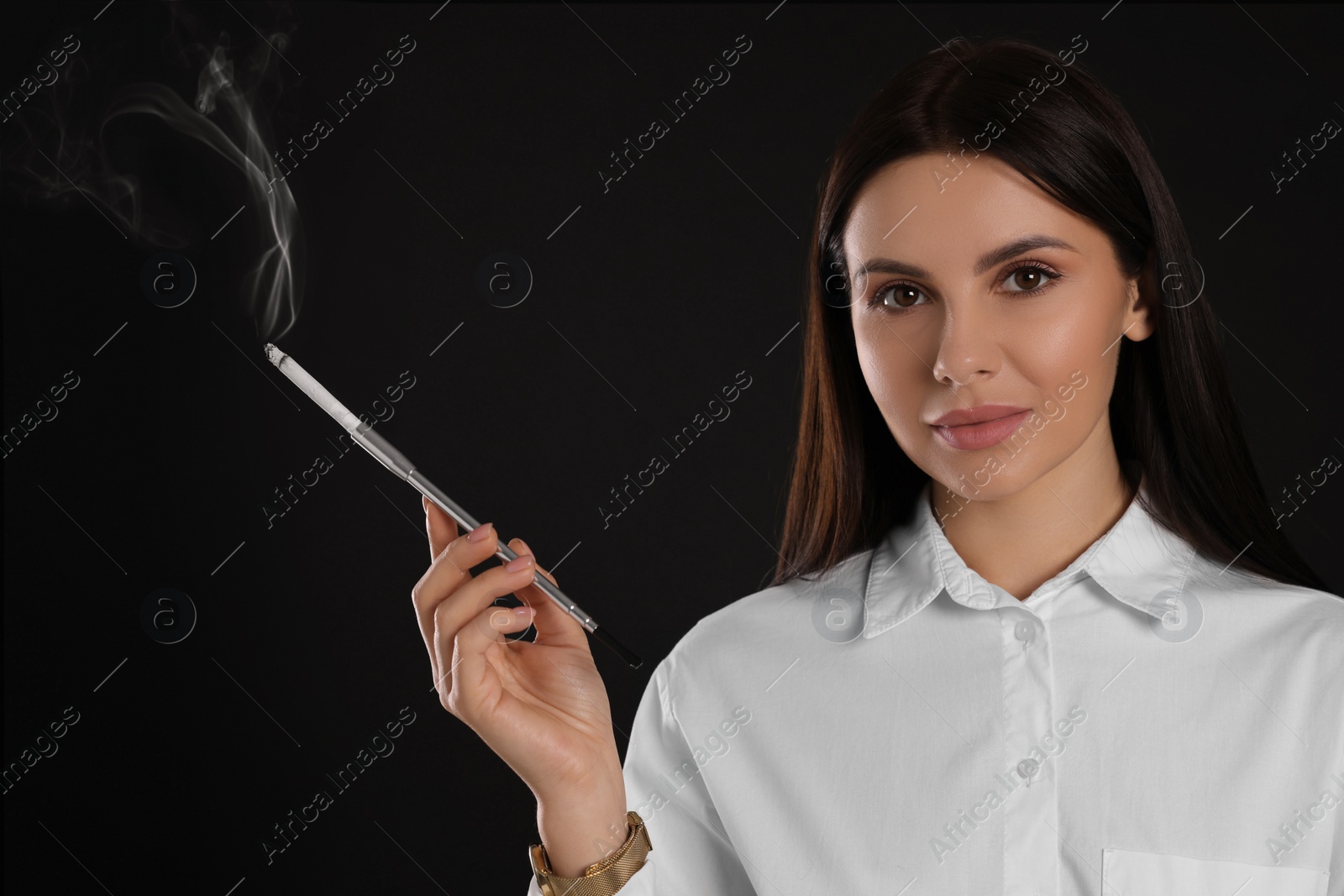 Photo of Woman using long cigarette holder for smoking on black background, space for text