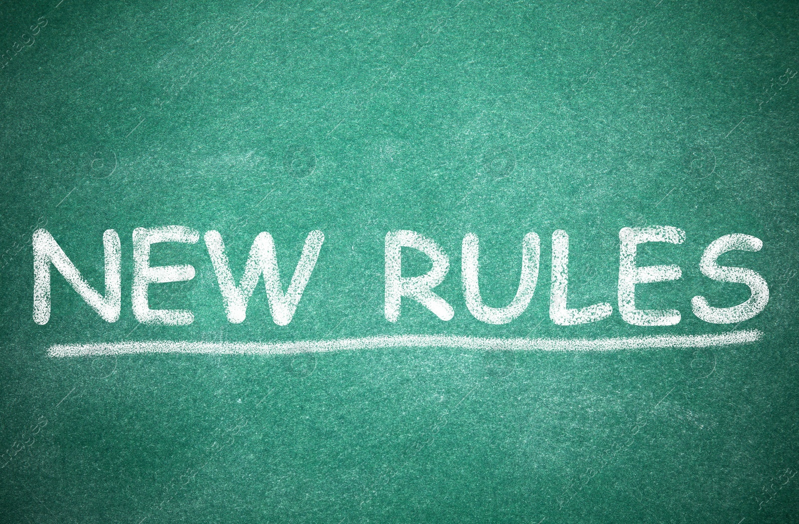 Image of Text NEW RULES written on green board