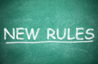 Image of Text NEW RULES written on green board