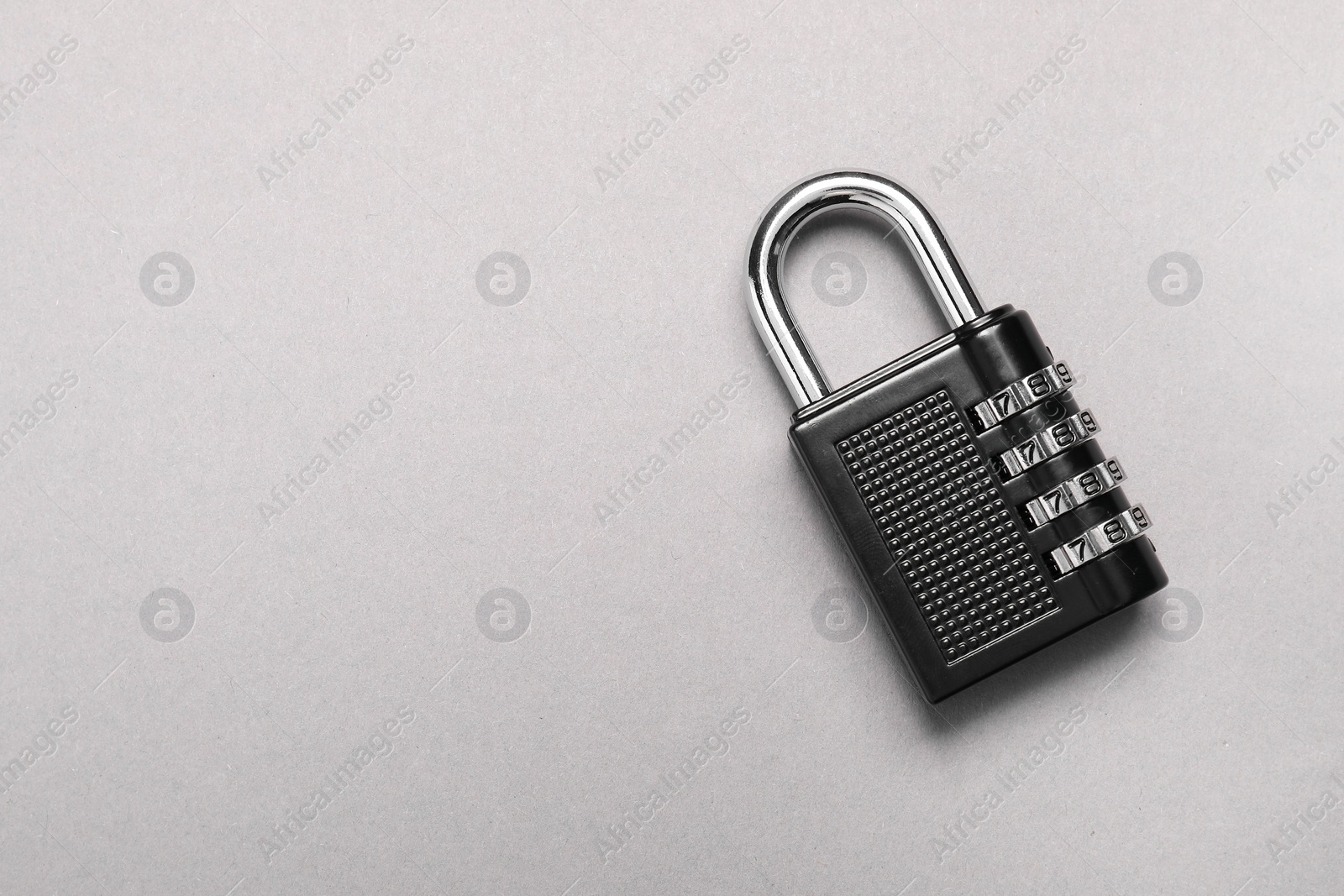 Photo of One steel combination padlock on grey background, top view. Space for text