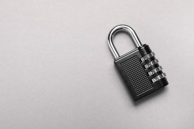 One steel combination padlock on grey background, top view. Space for text