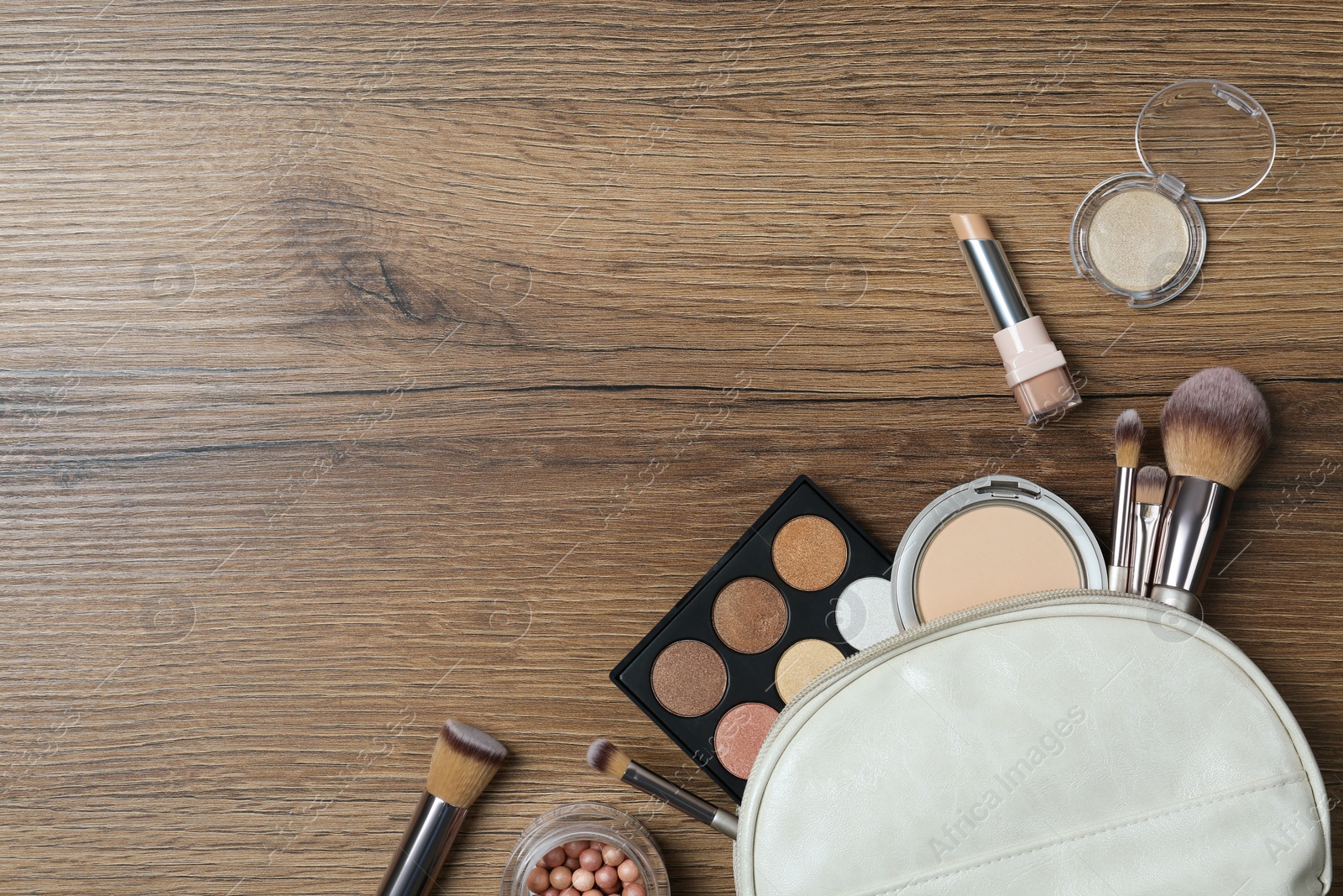 Photo of Flat lay composition with makeup products on wooden table, space for text